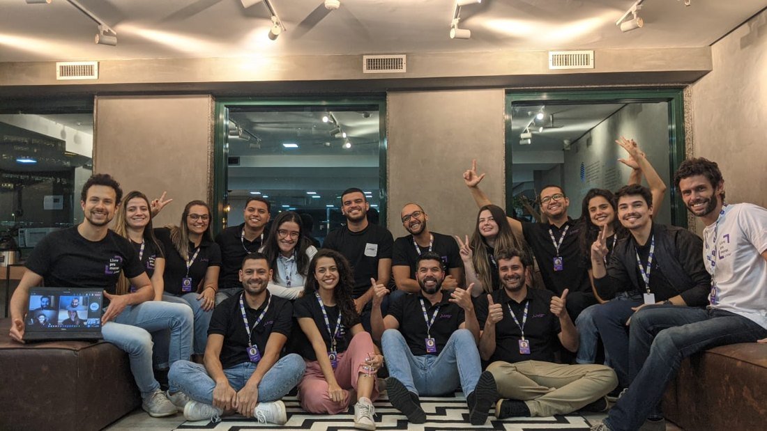 Equipe da Livar reunida e comemorando, com a marca Livre pra Morar ao fundo